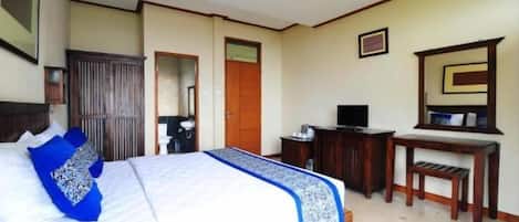 Un dormitorio con una cama, un escritorio, un televisor y un armario.