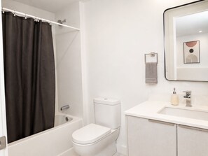 Une salle de bain avec une baignoire, des toilettes et un lavabo avec un miroir au-dessus.