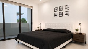 A modern bedroom with a large bed, a sliding glass door to a balcony, and a series of car-themed wall art. - Luxury 1.65M 4-Story Townhome 3bed/3bath in the Heart of Brickell (Miami)