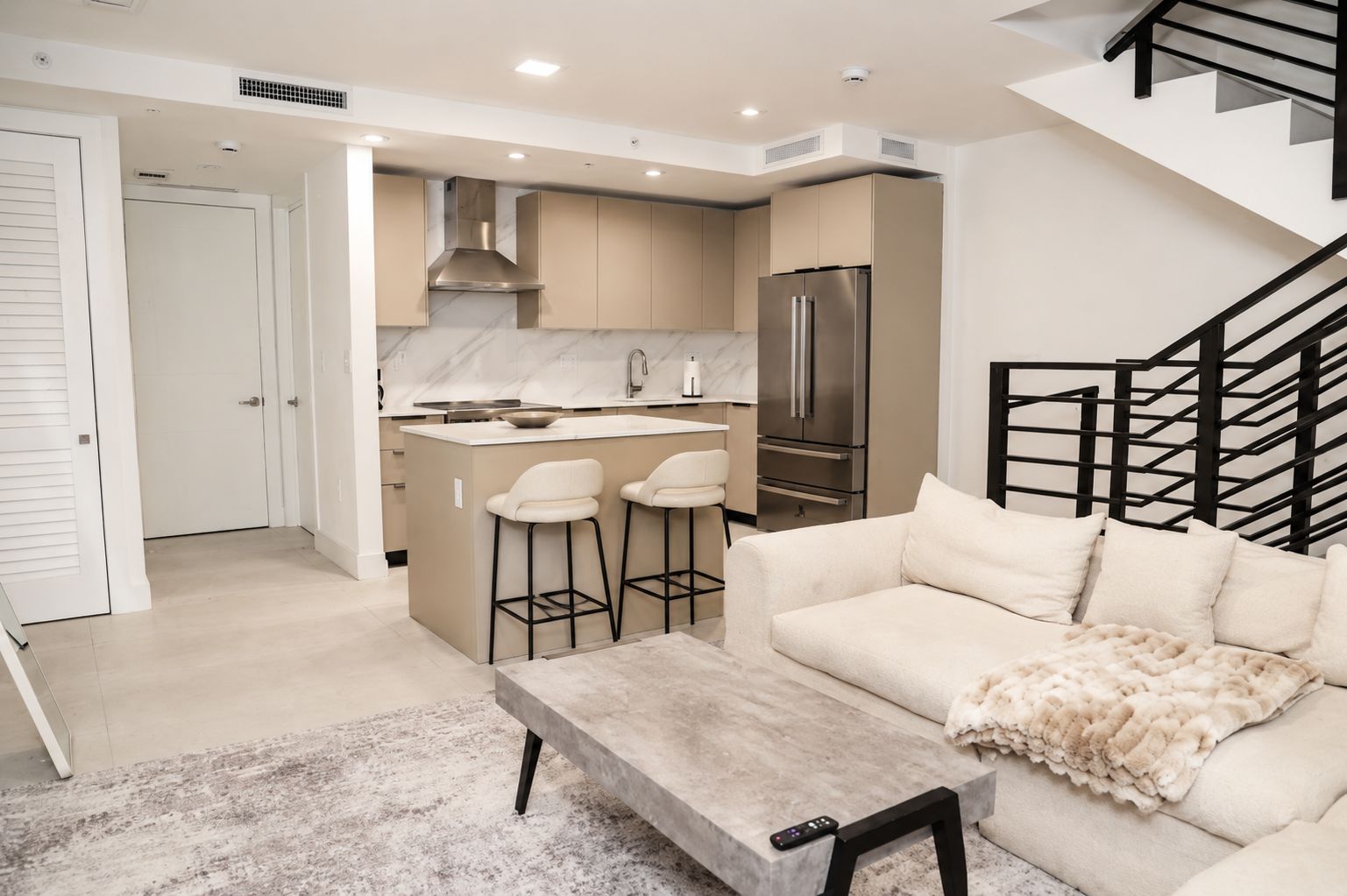 A modern apartment with a kitchen, dining area, and living room.