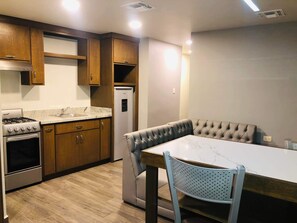 A modern kitchen with wooden cabinets, a gas stove, and a built-in refrigerator.