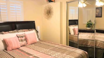 A bedroom with a bed, a mirror, and a wall decoration.