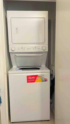 Una lavadora de carga frontal con panel de control y una etiqueta que dice 'limpia' en la puerta.