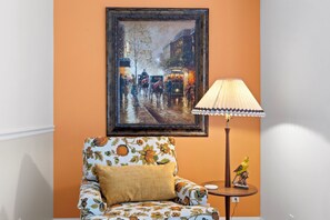 A room with a framed painting, a patterned armchair, a lamp, and a small table with a decorative item. - Steps to Oak Creek – A Peaceful Sedona Retreat Near Cathedral Rock (Sedona)