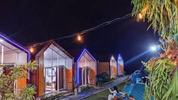 A campsite with tents and a building with a glass facade.