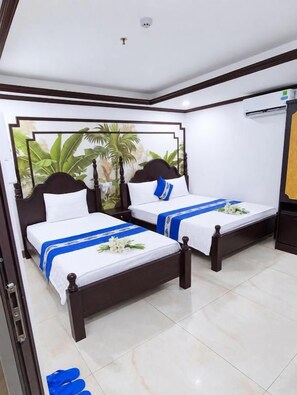 A hotel room with two beds, a large window with a view of greenery, and a ceiling-mounted air conditioning unit. - Gia Bao Hotel Near Tan Son Nhat Airport (Tân Bình)