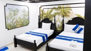 A modern hotel room with two beds, a green chair, and a small table. - Gia Bao Hotel Near Tan Son Nhat Airport (Tân Bình)