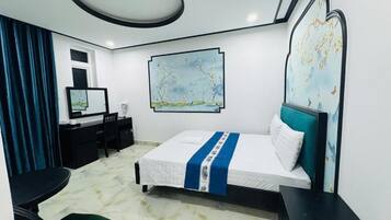 Une chambre d’hôtel avec un lit, un bureau, une chaise et un grand tableau au mur.