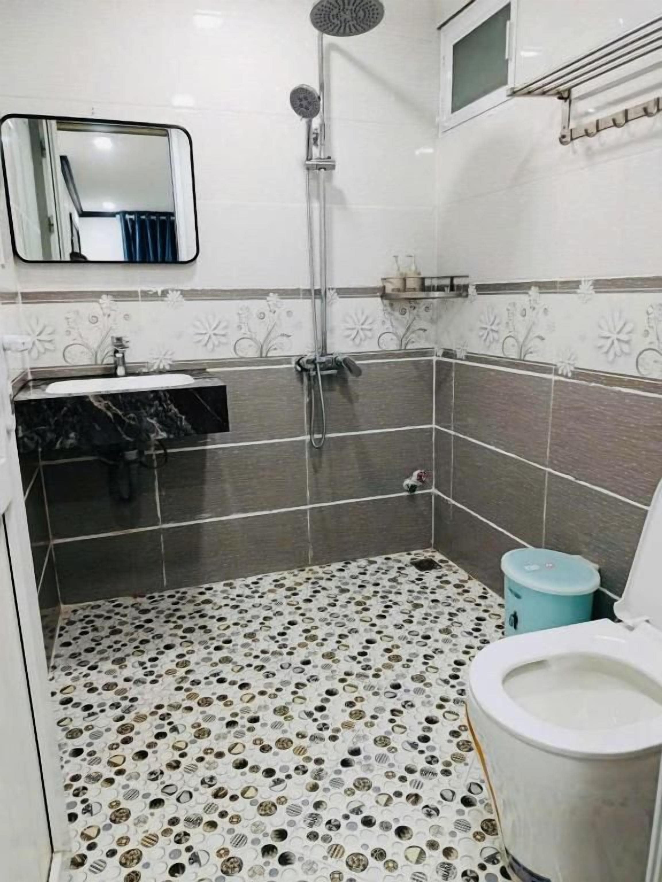 Een badkamer met een douche, wastafel en toilet.