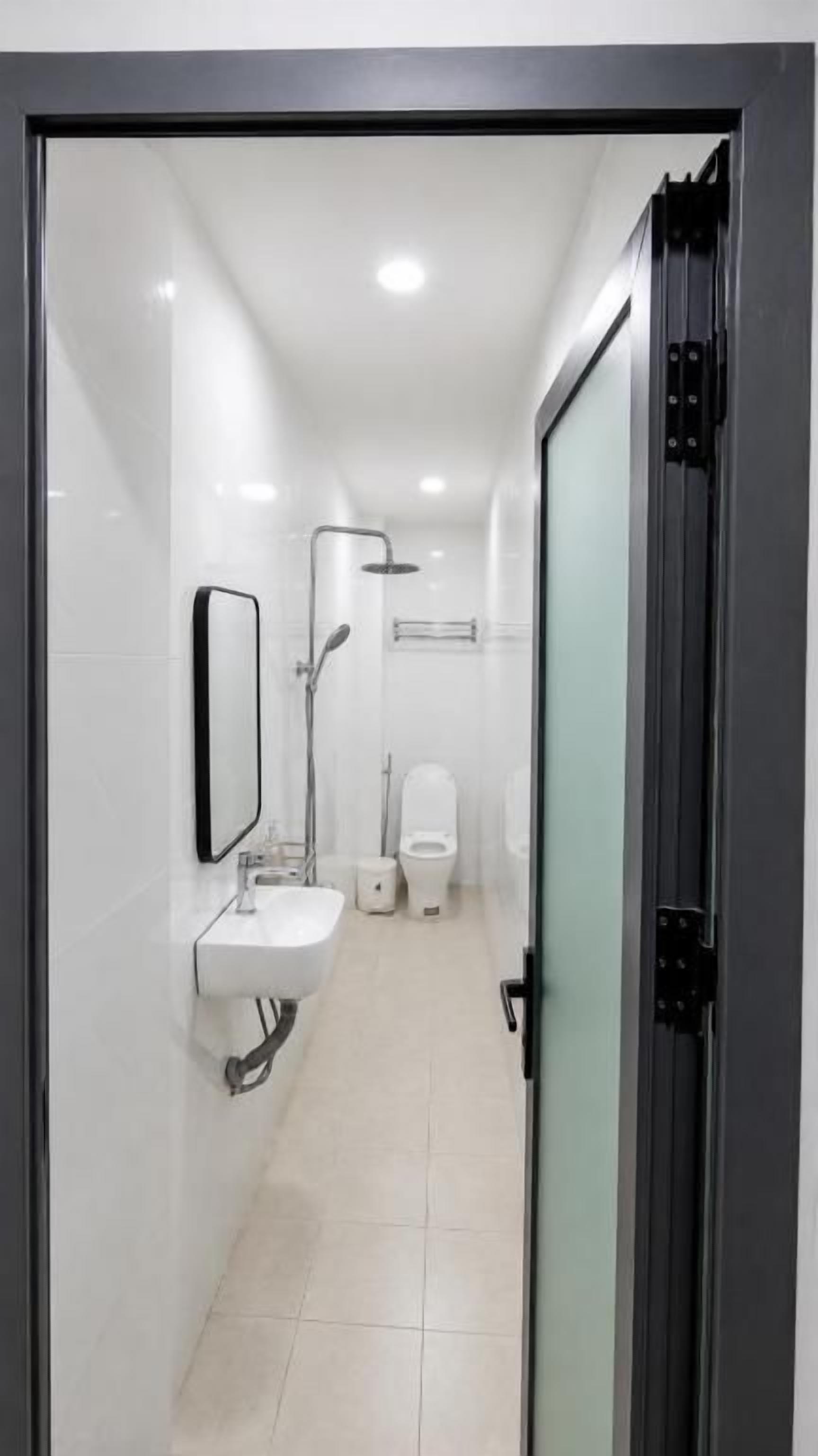 Un baño moderno con cabina de ducha de vidrio, un lavabo y un inodoro.