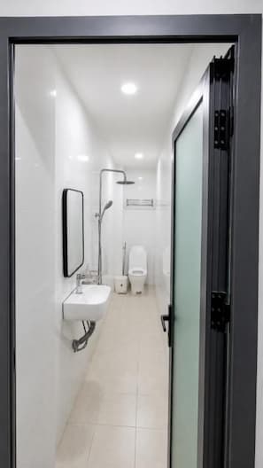 A modern bathroom with a glass shower enclosure, a sink, and a toilet. - Gia Bao Hotel Near Tan Son Nhat Airport (Tân Bình)