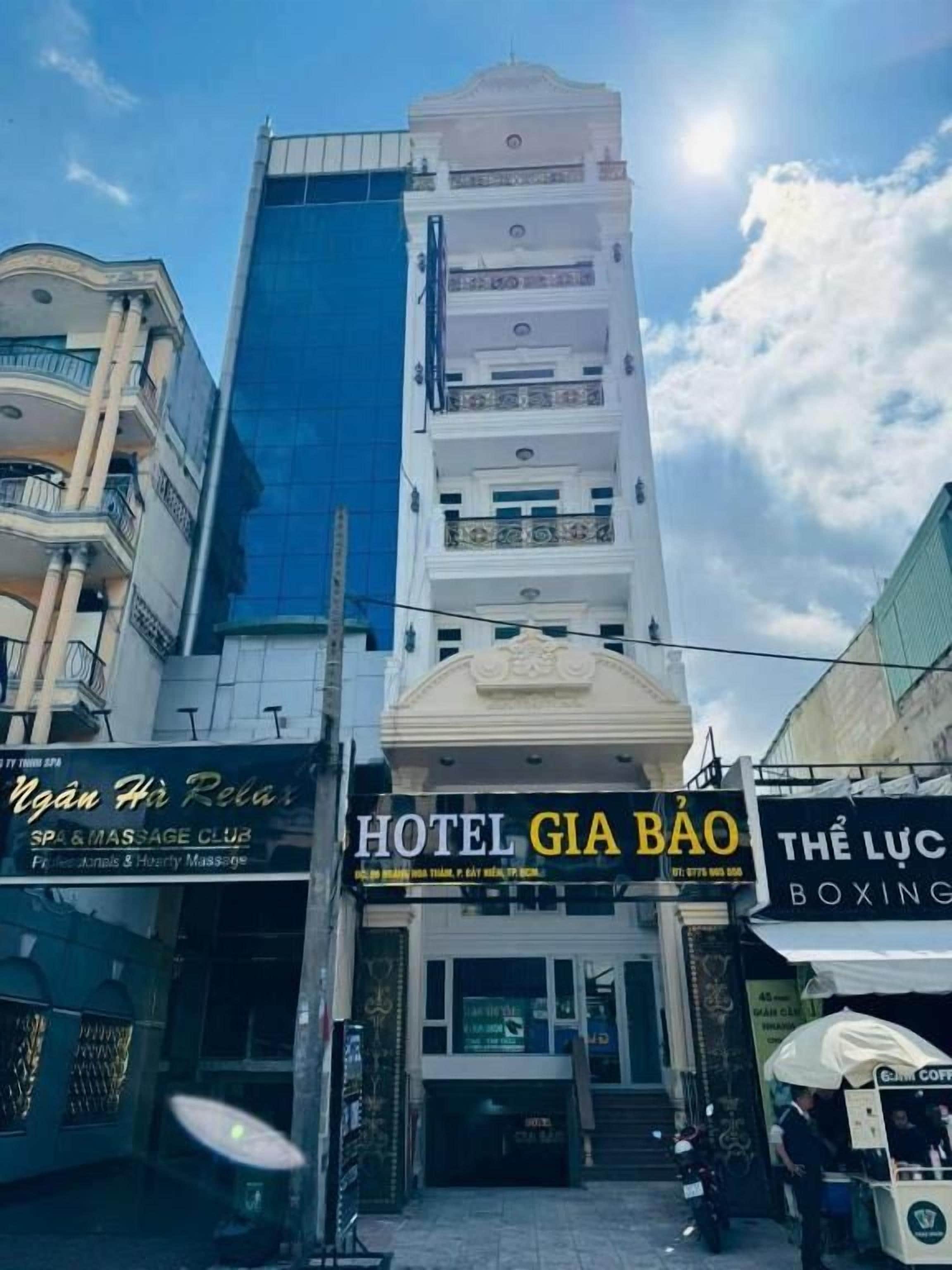 Un hotel con fachada moderna, un letrero de un club de masajes y un gimnasio de boxeo.