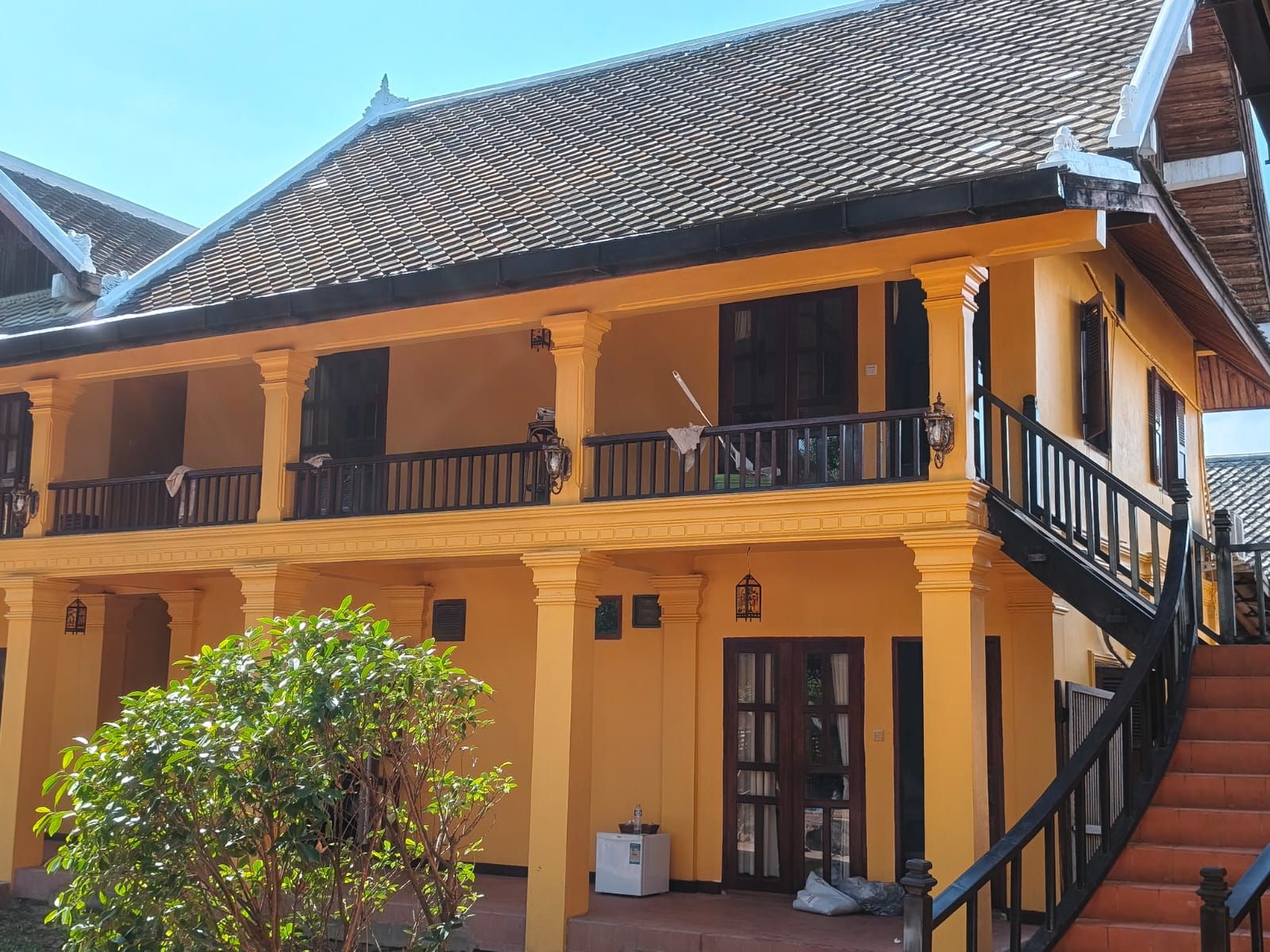 A two-story building with a balcony and a staircase.