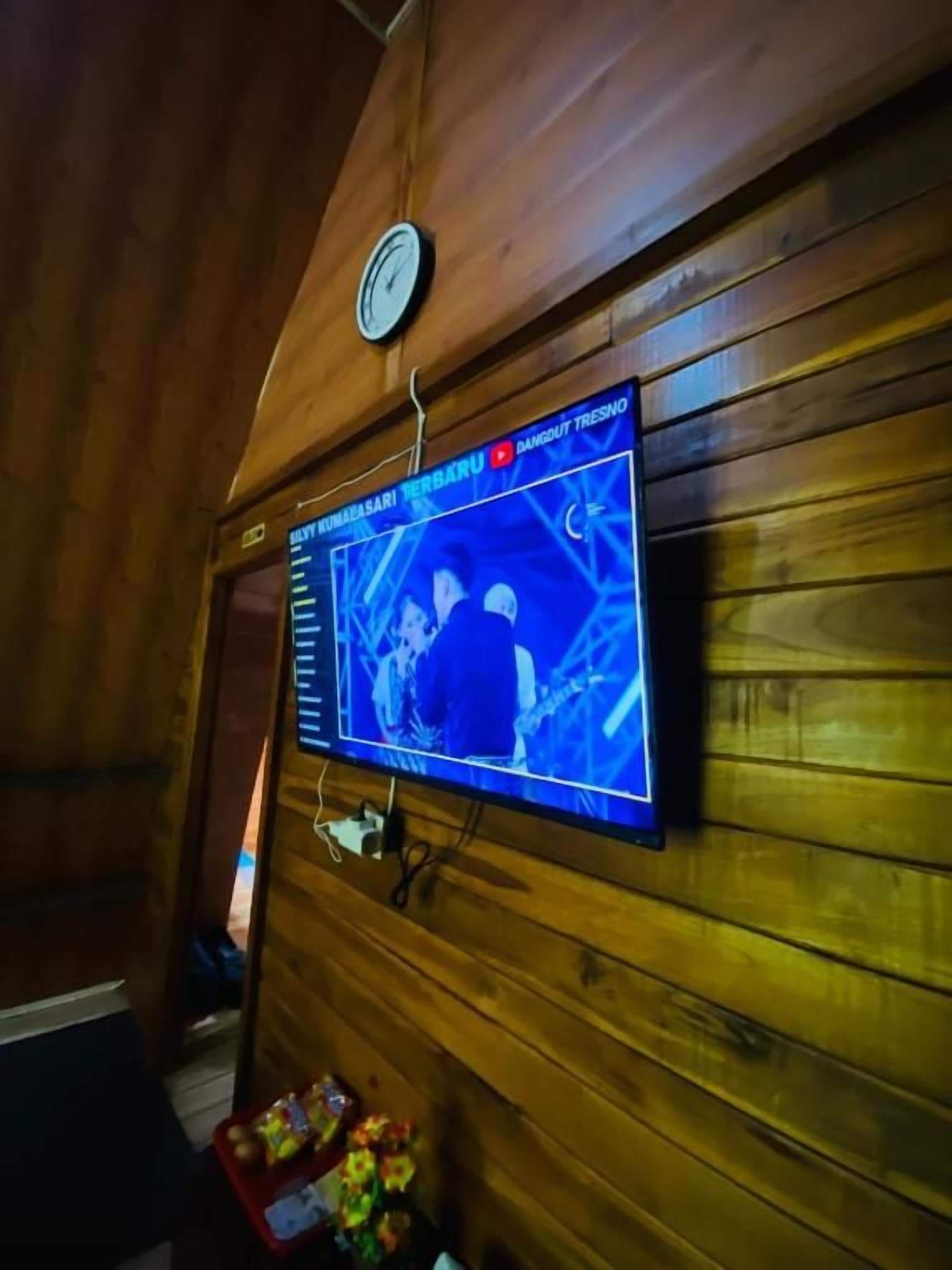 A wall-mounted television displaying a news program.