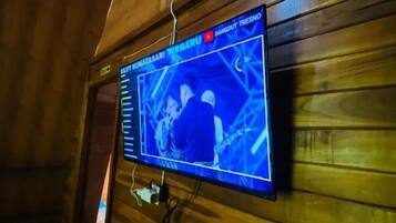 A wall-mounted television displaying a news program.