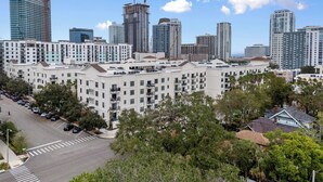 A multi-story residential building with a parking lot and trees in the foreground. - StayHaus - The Meridian Flat (St. Petersburg)