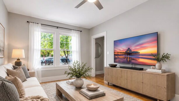 A modern living room with a sofa, coffee table, and TV. - StayHaus - The Meridian Flat (St. Petersburg)