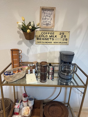Eine Kaffeestation mit einem Schild, das die Preise für Kaffee, kalte Milch und Beignets ausweist.