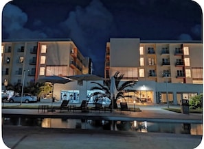 Un hotel amb diverses plantes, terrasses exteriors i zona de piscina.