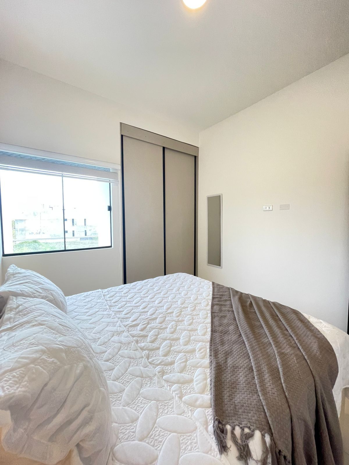 Une chambre à coucher avec un lit, une fenêtre et une armoire.