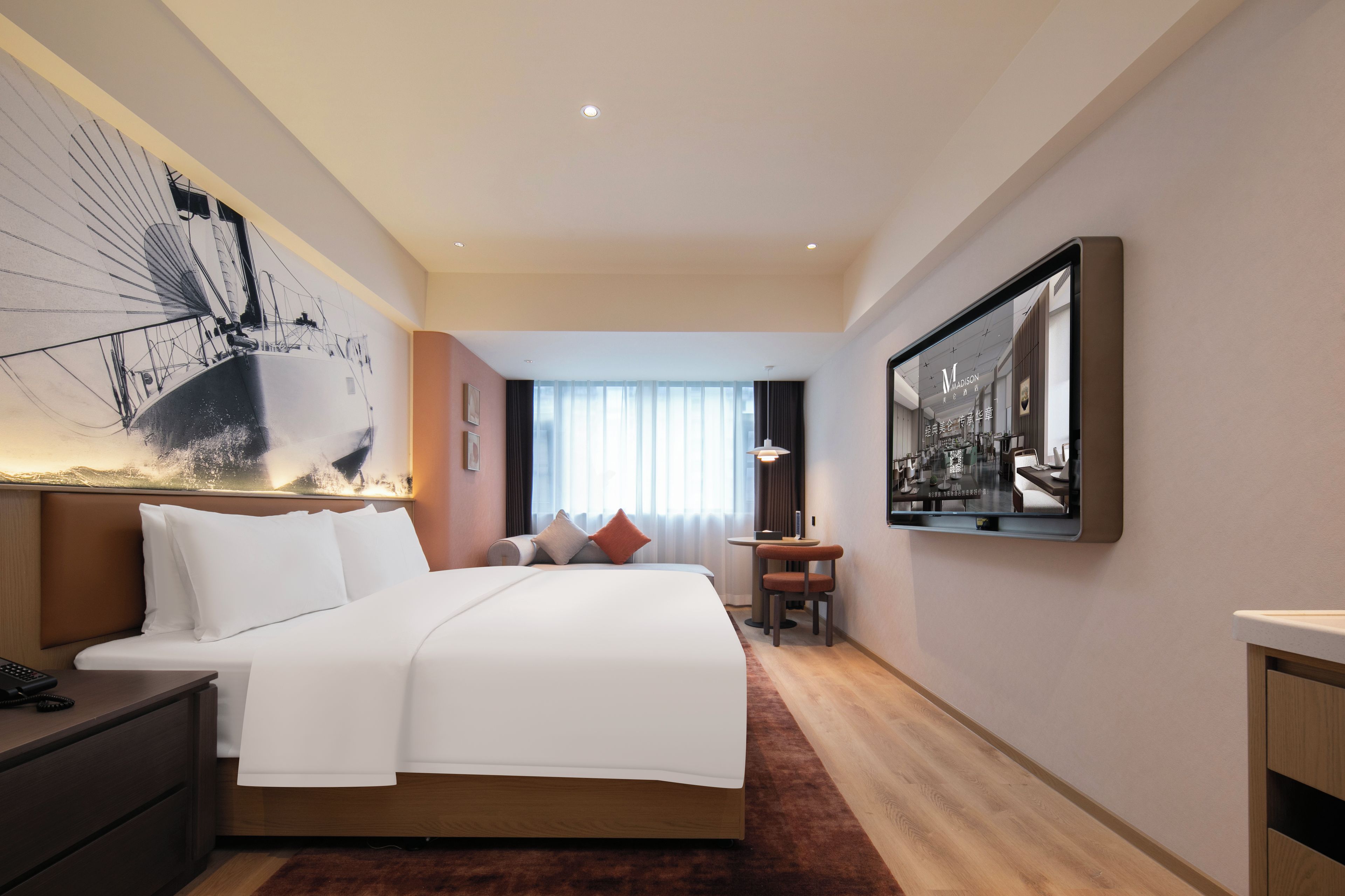 Una habitación de hotel con una cama grande, un escritorio, una silla y un ventanal amplio.