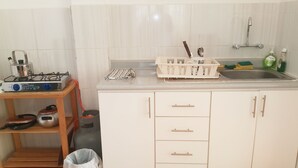 Una cucina con fornello a gas, lavello e pensili.
