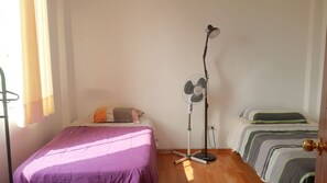 A bedroom with a bed, a standing fan, and a door. - Nice 1-bedroom apartment in lively Lima perfect for your stay (Lima)