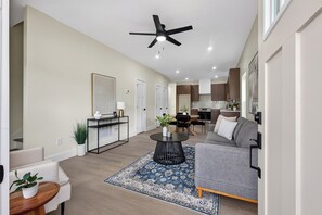 A spacious living area with a sofa, a coffee table, and a ceiling fan. - Johnston #A New 3b Home Near Downtown Knoxville (Knoxville)