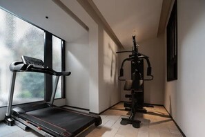 A home gym with a treadmill and weightlifting equipment.