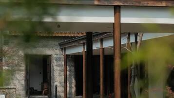 A modern building with a brick facade, a covered porch area, and a stone pathway leading to the entrance.