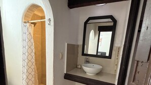 A bathroom with a white sink, a mirror, and a shower area. - House next to the beach in the hotel zone (Cancún)