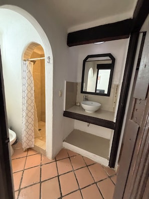 A bathroom with a white sink, a mirror, and a shower area. - House next to the beach in the hotel zone (Cancún)