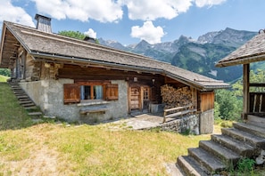 A rustic mountain cabin with a stone foundation, wooden exterior, and a steeply pitched roof. - Fernuy d’en Haut - Vue montagne - Plein Sud (LA CLUSAZ)