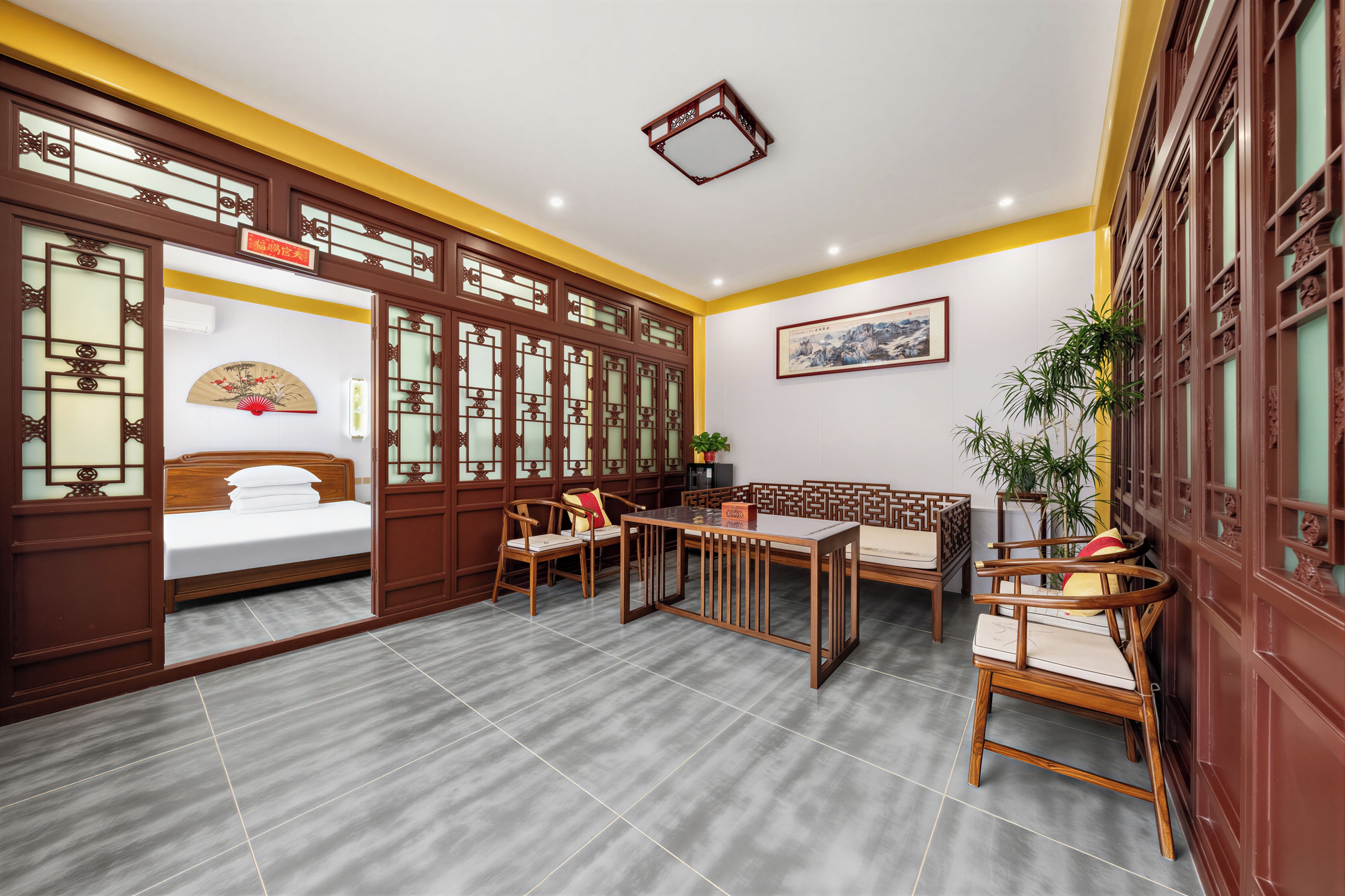 A traditional-style room with a bed, wooden furniture, and a decorative wall.