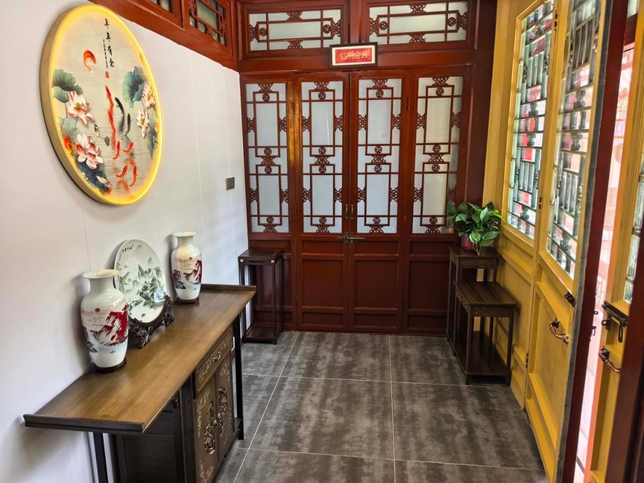 Un intérieur traditionnel avec une porte en bois, un sol carrelé et un tableau accroché au mur.