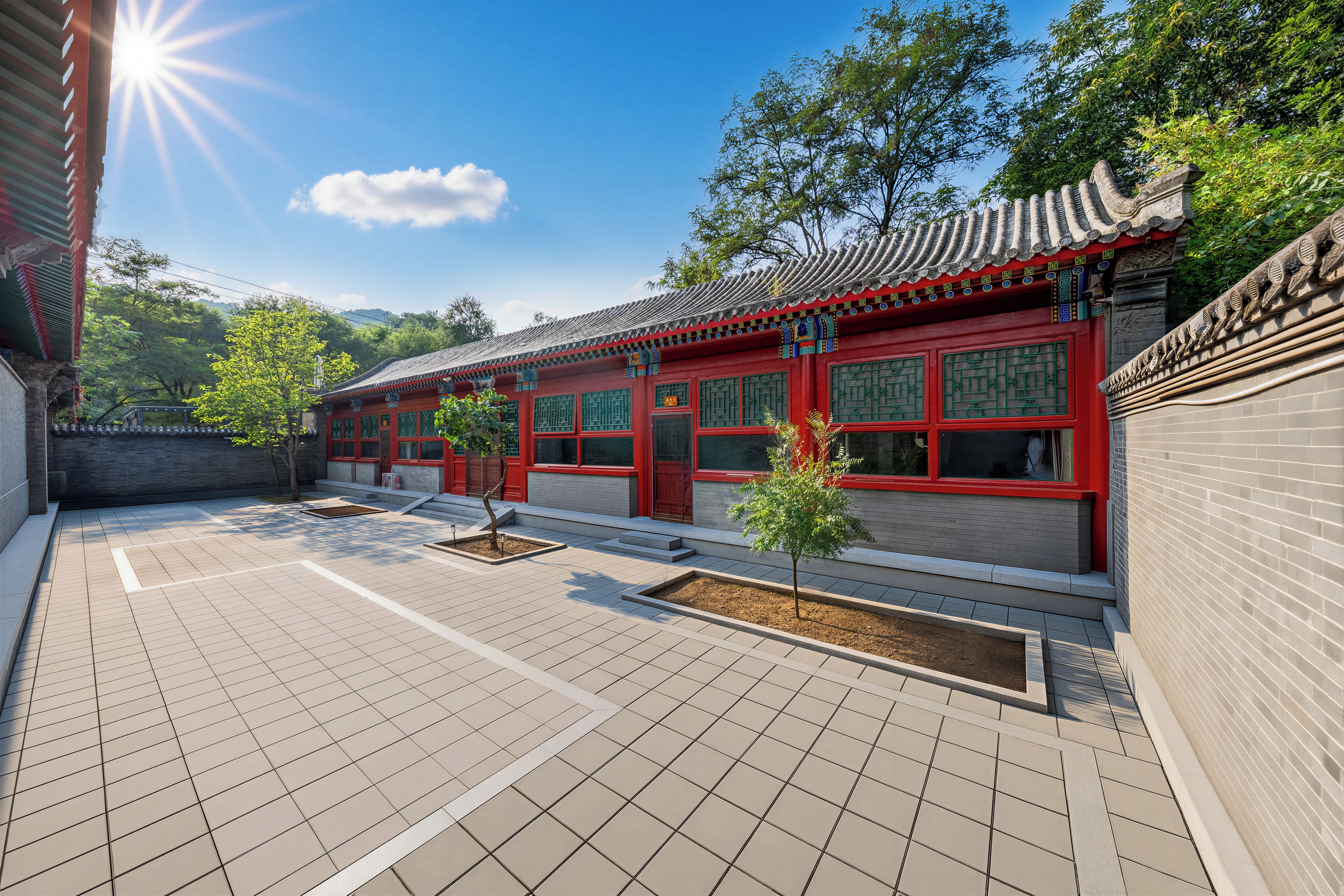 A traditional building with a tiled courtyard, red doors, and a tiled roof.