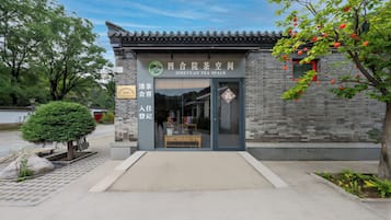 A traditional-style building with a tiled roof, a clear entrance, and a sign indicating it is a tea space.