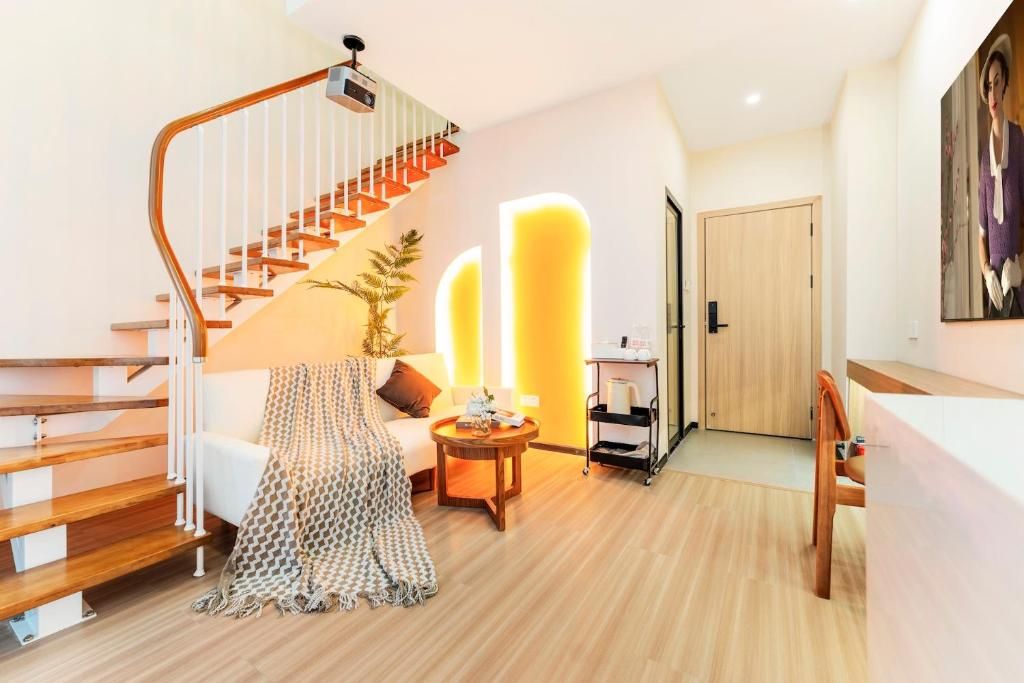 A modern interior with a wooden staircase, a sofa, a coffee table, and a door.
