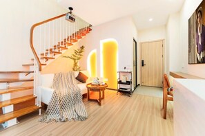 Een modern interieur met een houten trap, een bank, een bijzettafeltje en een deur.