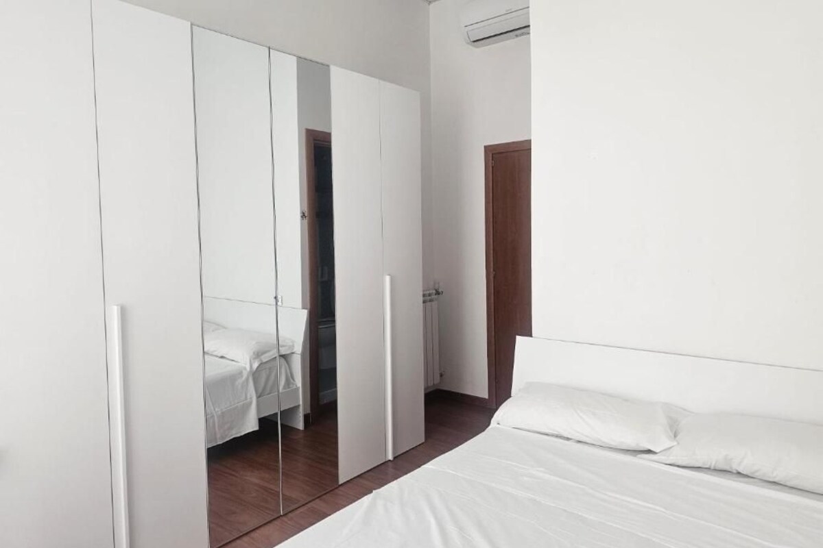 Une chambre à coucher avec un lit, une armoire et un miroir.
