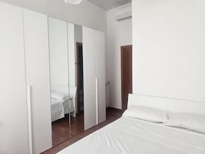 Une chambre à coucher avec un lit, une armoire et un miroir.