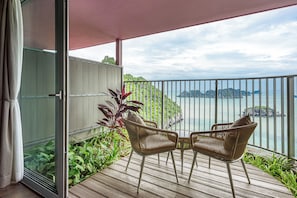 A balcony with two wicker chairs, a wooden deck, and a view of the sea and islands. - Vela Cat Ba Beach Resort - Flamingo Sea & Sand (Cat Hai)