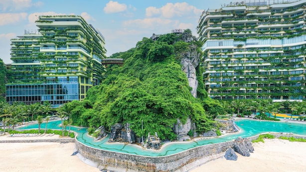 Un resort con diversi edifici a grattacielo, una roccia centrale e una zona piscina.