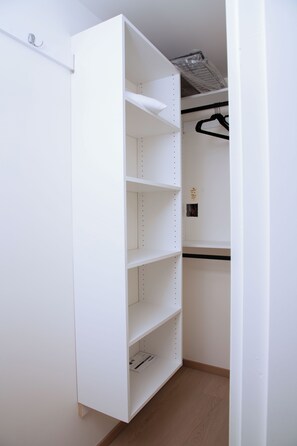 A white closet with open shelves and a hanging rod. - Serene 2-bedroom apartment with AC in charming Delta (Delta)