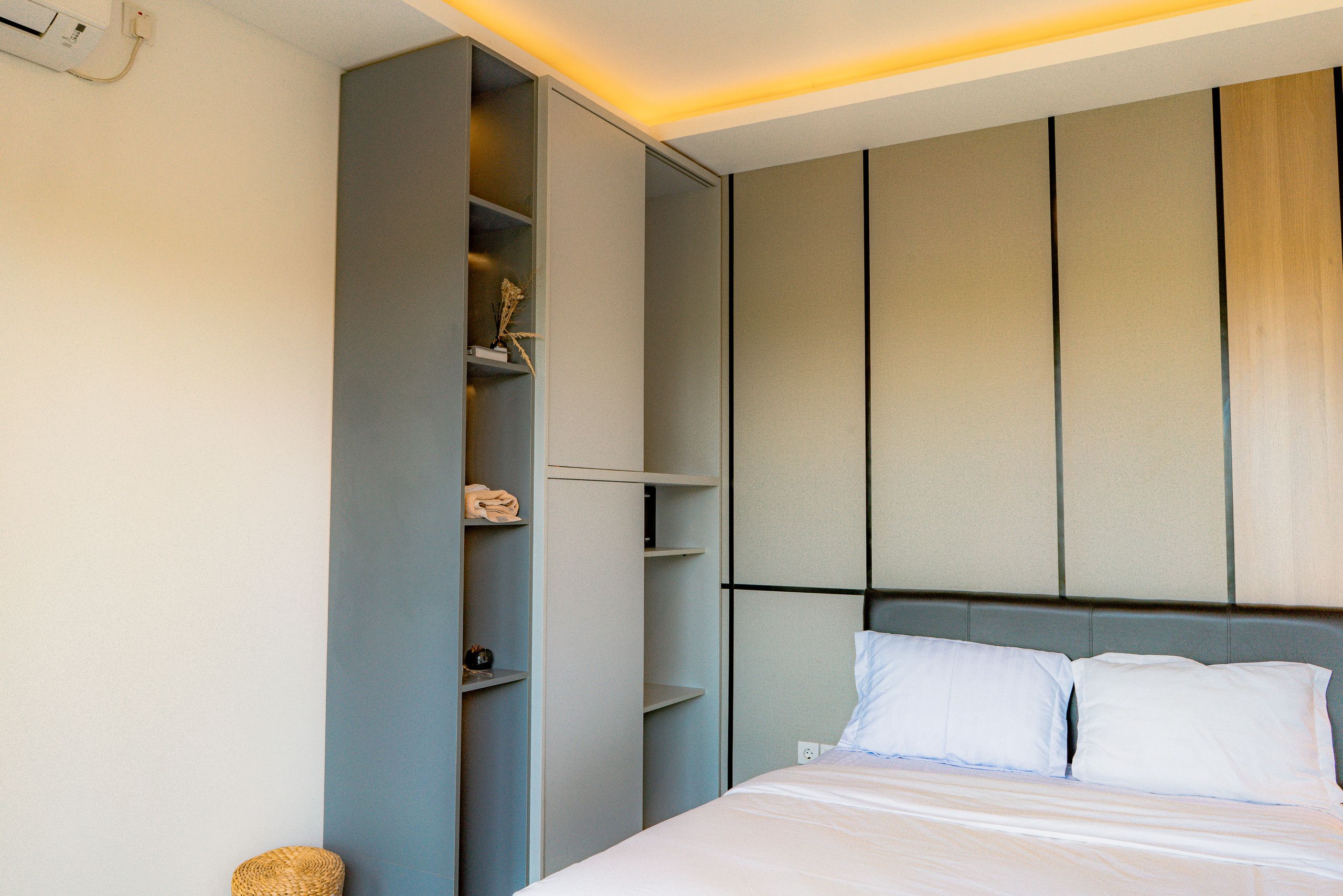 A bedroom with a bed, a wardrobe, and a nightstand.