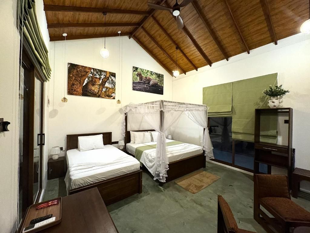 A room with two beds, a ceiling fan, and a large window.