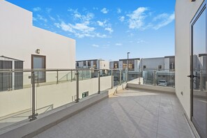 A modern building with a flat roof terrace, glass railings, and a clear sky. - Luxury 5-Bedroom Townhouse with Private Pool in Dubai (Dubai)