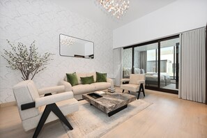 A modern living room with a sofa, armchairs, a coffee table, and a large mirror. - Luxury 5-Bedroom Townhouse with Private Pool in Dubai (Dubai)