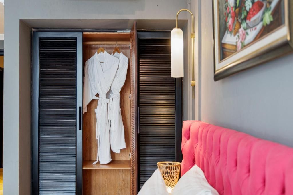 Une pièce comprenant un lit, une armoire en bois et un luminaire fixé au mur.