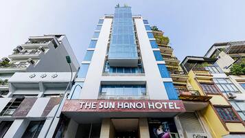 A multi-story hotel with a prominent sign for 'The Sun Hanoi Hotel' at the ground level.